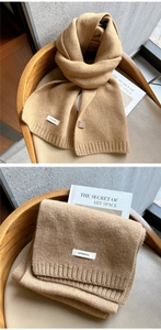 Macro detail of camel 100% wool scarf showing high-quality ribbed knit texture and soft fabric