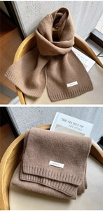 Detail of 100% wool knitted scarf in camel with soft texture and ribbed edges