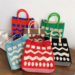 Set of six colorful knitted handbags with geometric patterns on a rustic wooden table