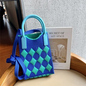 Detail of blue and green checkered knit mini tote bag with dual handles and shoulder strap