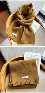 Detailed close-up showing 100% wool material and ribbed knit texture of mustard yellow scarf