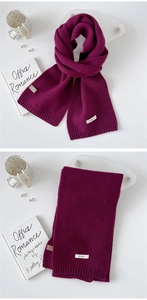 Detail of 100% wool knitted scarf showing ribbed trim and dark purple texture