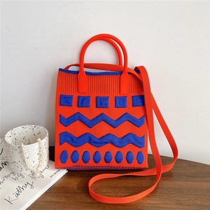 Detail showing orange and blue geometric knitted phone bag with soft round handles