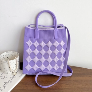 Close-up of purple knitted crossbody bag with diamond pattern and round handles