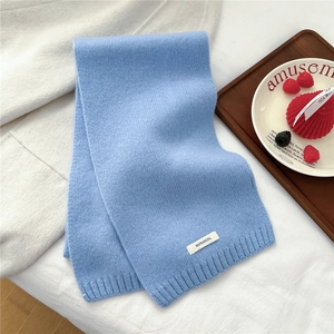 Close-up of light blue 100% wool knitted scarf showing fine ribbed texture and soft fabric