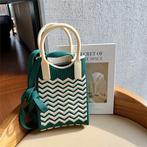 Macro detail of wave-patterned knit texture on a mini crossbody bag with top handles