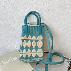 Detail of blue knitted mini crossbody bag featuring white geometric diamond patterns