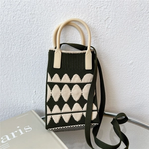 Macro shot of green geometric knitted phone bag with cream resin ring handle and texture