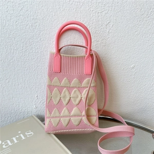 Close-up of pink and beige knitted phone bag with geometric pattern and round handles