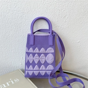 Detail of purple knitted mini crossbody bag with geometric patterns and round handle