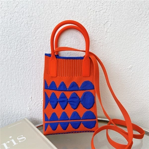 Close-up of orange and blue knitted phone bag with wave patterns and shoulder strap