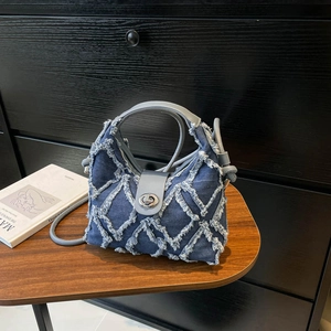 Borsa a secchiello in denim blu navy con motivo trapuntato a frange e manici in pelle