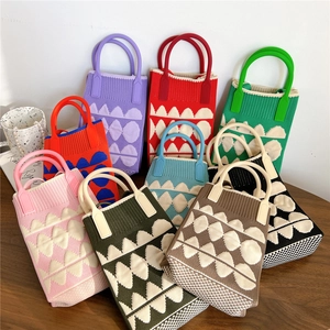 Colorful mini knitted phone bags with wavy heart patterns and rigid plastic handles