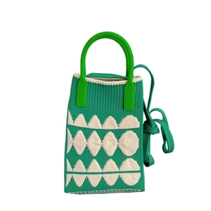 Mini green knitted tote bag with white geometric patterns and a long shoulder strap
