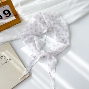 Détail du foulard en mousseline à fleurs lavande sur fond blanc léger