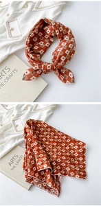 Close-up of caramel orange silk scarf with cream checkerboard pattern and stitched edges