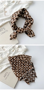 Detail of checkered brown cotton linen scarf with floral print and white hemmed edges