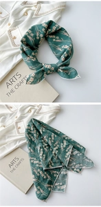 Detail view of dark green floral cotton-linen scarf with delicate rolled edges and print