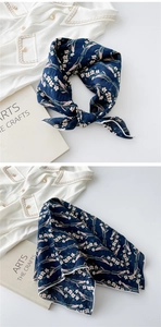Detail of navy blue floral cotton linen scarf showing texture and white hemmed edge