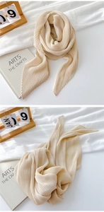 Detail of beige pleated cotton linen scarf with elegant vertical accordion folds