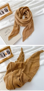 Detailed close-up of pleated cotton linen scarf with fine vertical accordion folds