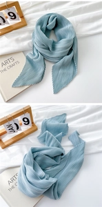 Close-up of light blue pleated scarf with vertical organza texture and silky sheen