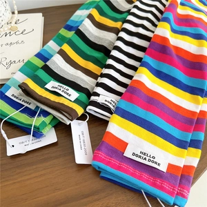 Colorful striped knitted arm sleeves in various colors displayed on a wooden surface
