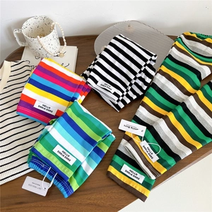 Colorful striped arm sleeves in rainbow patterns laid neatly on a wooden surface