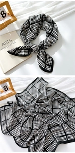 Detail of black and white houndstooth cotton linen scarf with high density knit texture
