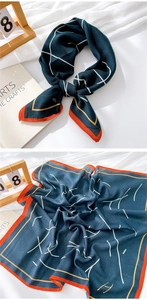 Detail of navy cotton linen scarf with white geometric lines and orange hem