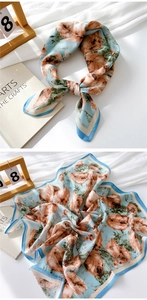 Detail of light blue cotton linen scarf featuring realistic brown leaf print and silk texture