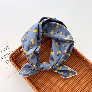 Foulard in cotone blu con stampe di ciliegie gialle su un vassoio di rattan