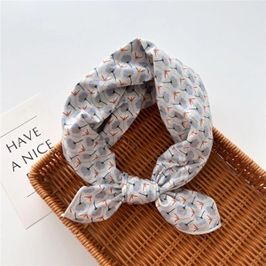 Dettaglio di un foulard in cotone con stampa floreale blu e arancione su grigio chiaro