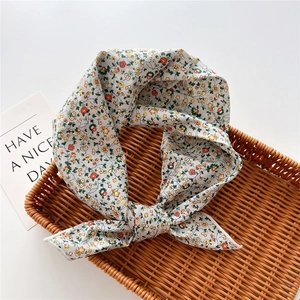 Dettaglio di un foulard in cotone lino a fiori colorati in un cestino di vimini