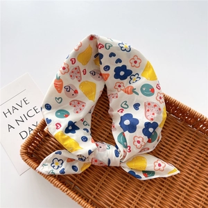 Detail of artistic floral and cartoon print cotton linen scarf in a woven basket