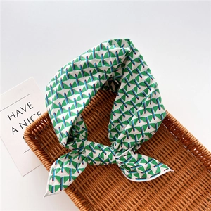 Detail of silk-like cotton linen square scarf with geometric patterns in a rattan tray