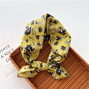 Dettaglio di sciarpa in cotone e lino a fiori vintage in un cesto di vimini intrecciato