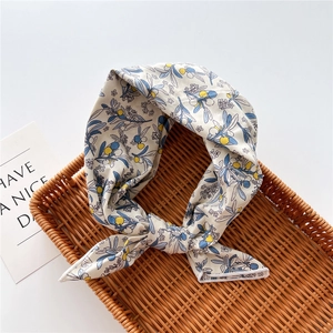 Dettaglio del foulard in cotone e lino con motivo floreale a foglie blu e frutti gialli