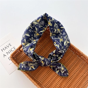 Dettaglio della sciarpa in cotone e lino blu navy con stampa di frutti e bordo verde
