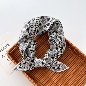 Detail of black and white geometric pattern scarf tied on a natural woven tray