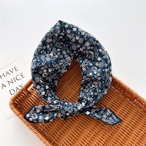 Foulard in cotone e lino blu scuro con fiori bianchi su un vassoio di vimini elegante
