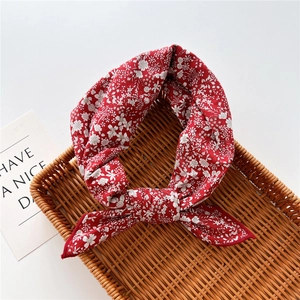 Detail of red floral cotton linen scarf with small white flowers in a woven tray