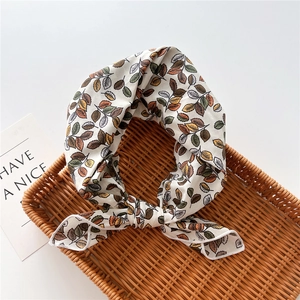 Detailed shot of floral cotton linen neckerchief with leaf pattern in a woven tray