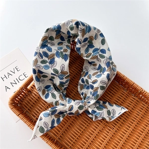 Detail of leaf print cotton linen scarf with fine stitched edges on a woven tray
