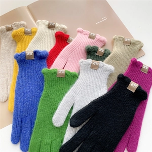 Colorful knitted winter gloves with ruffled cuffs and stylish label in various bright colors