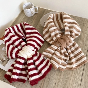 Sciarpe a maglia a righe rosse e marroni con etichette in pelle su fondo legno