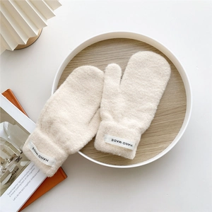 Detail of knit winter mittens in cream with thick fleece and Hand Made woven label