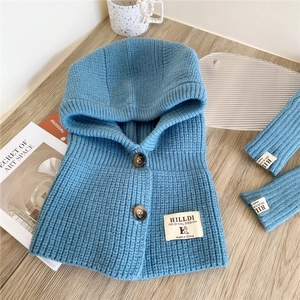 Close-up of blue knitted hood scarf set with thick texture and button details