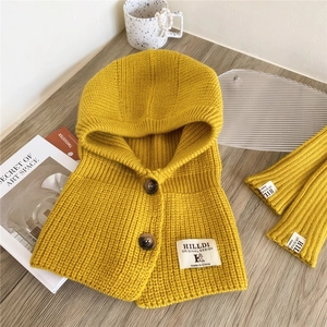 Detail of chunky knit balaclava hood and arm sleeves with buttons in vibrant yellow