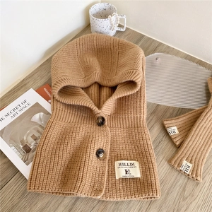 Knitted hooded scarf with buttons in khaki, showing texture and detail on wooden surface